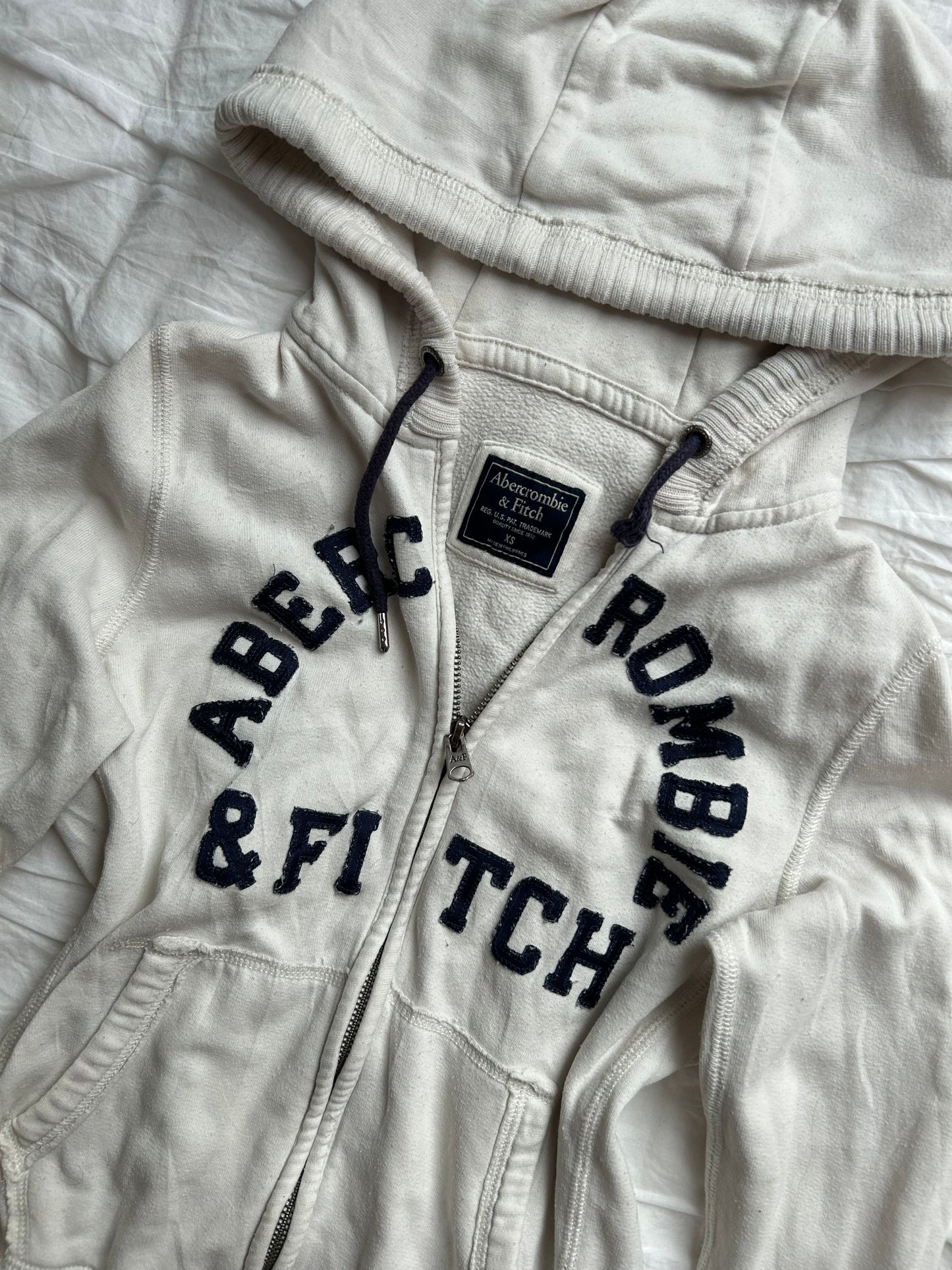 Weiße Abercrombie & Fitch Sweatshirtjacke mit dunkelblauem Logo-Schriftzug